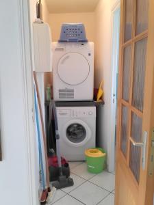 a laundry room with a washer and a washing machine at Maison Indépendante Au Calme in Mahalon