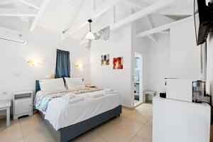 a bedroom with a bed in a white room at Hotel Selini in Agios Nikitas