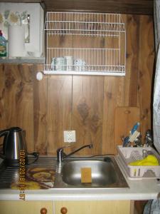 a kitchen with a sink and a shelf above it at Pokój w centrum in Ustroń