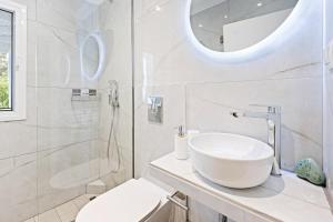 a white bathroom with a sink and a shower at Hotel Selini in Agios Nikitas