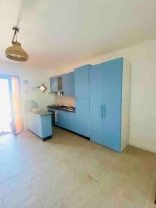 a kitchen with blue cabinets and a tile floor at Authentic Puglia Seaside Condo in Scalo dei Saraceni Manfredonia