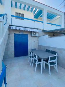 a patio with a table and chairs and a blue door at Authentic Puglia Seaside Condo in Scalo dei Saraceni Manfredonia +2 photos