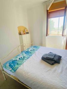 a bedroom with a bed with a towel on it at Authentic Puglia Seaside Condo in Scalo dei Saraceni Manfredonia