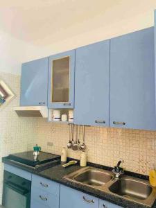 a kitchen with blue cabinets and a sink at Authentic Puglia Seaside Condo in Scalo dei Saraceni Manfredonia