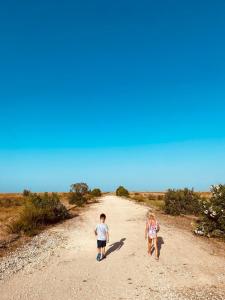 two children are walking down a dirt road at Authentic Puglia Seaside Condo in Scalo dei Saraceni Manfredonia