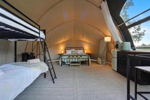 a bedroom with a bed and a table in a tent at Cloud Nine Tent #3 - The Oak Oasis in Hermosa