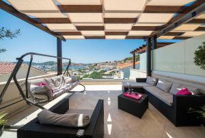 a living room with a couch and chairs on a balcony at The Tribunj Suites in Tribunj