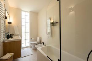 a bathroom with a tub and a toilet and a sink at Wave Song Villa in Santo Isidoro +51 photos