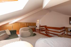 a attic room with a bed and a couch at Wave Song Villa in Santo Isidoro