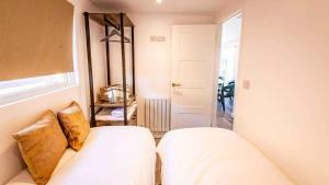 a bedroom with a bed with white sheets and gold pillows at Whitemills Wake and Aqua Park Lodge One in Richborough