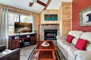 ein Wohnzimmer mit Couch und Kamin in der Unterkunft Magnificent Cabin with Hot-tub and Hiking Trails Near in Gatlinburg, Tennessee in Cartertown