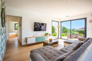 a living room with a couch and a table at Villa Zephyr by Villa Plus in Tourbes