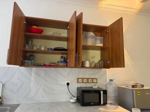 a kitchen with wooden cabinets and a microwave on a counter at Aligna Bamburi in Mombasa