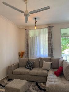 a living room with a couch and a ceiling fan at Aligna Bamburi in Mombasa