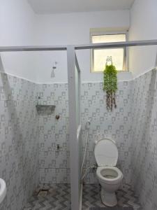 a small bathroom with a toilet and a window at Aligna Bamburi in Mombasa