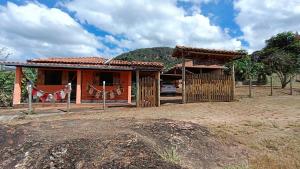 une petite maison avec une clôture devant dans l'établissement Sítio, Casa grande, bem espaçosa, em Itambe do Mato Dentro, Cabeça de Boi, à Itambé do Mato Dentro