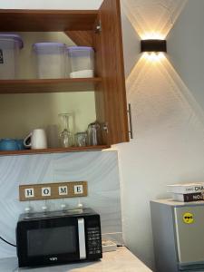 a kitchen with a microwave and a light on a counter at Aligna Bamburi in Mombasa