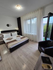 a large bedroom with a large bed and a chair at Vila Ozon in Ranca +81 photos