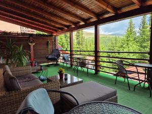 a screened in porch with chairs and tables and a view at Vila Ozon in Ranca +80 photos