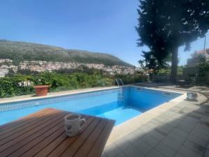 a swimming pool with a cup on a wooden deck at Central in Dubrovnik