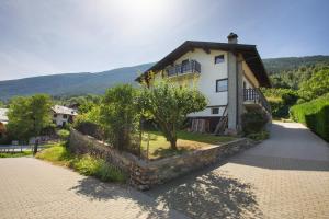 a house with a stone wall next to a street at Case Vacanza Newmood - Intera Villa in Aymavilles
