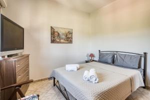 a bedroom with a bed and a flat screen tv at Selbesi Holiday Cottage in the countryside - Elevated View in Kómi