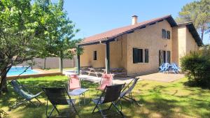a group of chairs in front of a house at L'OREE DE LA PLAGE, 15 pers, Charmante Maison rénovée classée 3 étoiles - Piscine chauffée - Terrain de pétanque - Ping pong à Vieux-Boucau in Vieux-Boucau-les-Bains