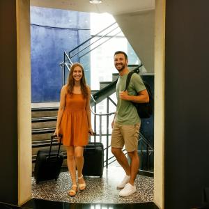 a man and a woman standing in a hallway with their luggage at Plaza Hotel & Living Frankfurt in Frankfurt/Main