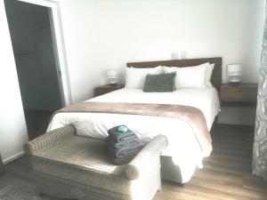 a bedroom with a large bed and a chair at Skye in Paternoster