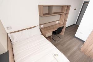 a small bedroom with a bed and a desk at Ensuite Single Room in Central Coventry in Coventry