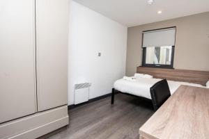 a white bedroom with a bed and a mirror at Ensuite Single Room in Central Coventry in Coventry