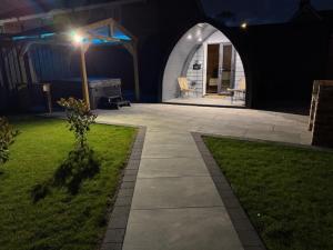 Un patio trasero de noche con una casa blanca con una farola. en Oakwood Farm Chester, en Chester 2 fotos más