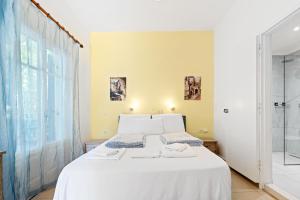 a bedroom with a white bed and a glass shower at Hotel Selini in Agios Nikitas