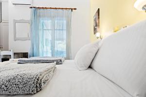 a bedroom with a white bed and a window at Hotel Selini in Agios Nikitas
