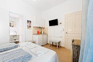 a small white room with a bed and a kitchen at Hotel Selini in Agios Nikitas