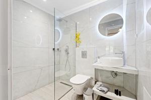 a bathroom with a shower and a toilet and a sink at Hotel Selini in Agios Nikitas