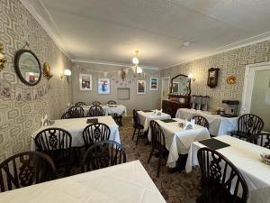 a restaurant with white tables and chairs and a mirror at The Scala Hotel in Blackpool