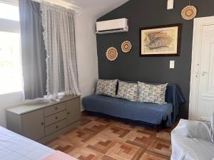 a bedroom with a bed and a couch and a window at Sofita garden in Nea Michaniona