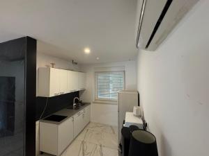 a small kitchen with white cabinets and a refrigerator at Central in Dubrovnik
