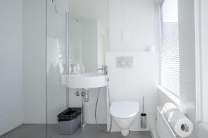 a white bathroom with a toilet and a sink at Omena Hotel Turku Kauppiaskatu in Turku +18 photos