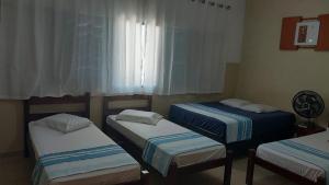 ピラスヌンガにあるHotel JF2のベッドが3つと窓のある部屋