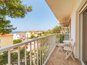 a balcony with two chairs and a view of the ocean at Fia 70s Beach Apartment in Rab