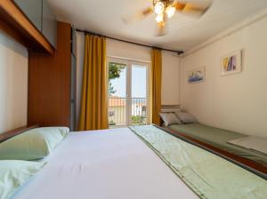 a bedroom with two beds and a window at Fia 70s Beach Apartment in Rab