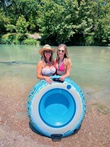 dwie kobiety stoją w wygodnej łódce na wodzie w obiekcie Luxury Safari Tent on the San Marcos River - Stunning Glamping Spot near Kingsbury, Texas w mieście Staples