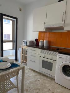 a kitchen with a washing machine and a table at Estocolmo Lovely in Gran Tarajal