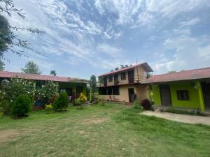a house with a green and yellow house at HOSTEL ANIMAL LOvE in Sauraha