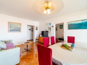 a living room with a table and red chairs at Fia 70s Beach Apartment in Rab