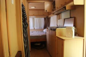 una piccola cucina con un letto in una casetta di Full-Service Caravan ad Albertslund