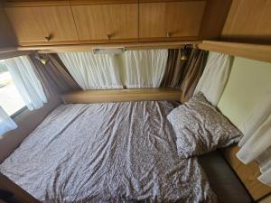 un piccolo letto in una piccola camera in una roulotte di Full-Service Caravan ad Albertslund