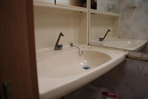 un lavandino in bagno con due rubinetti e uno specchio di Full-Service Caravan ad Albertslund
